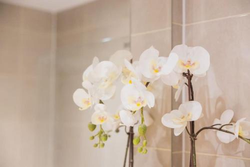 a bunch of white flowers in a vase at Cosy City Centre Apartment with Parking in Birmingham