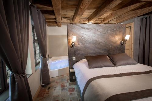 a bedroom with a bed and a bath tub at Le 1615 - Luxe et Spa in Colmar