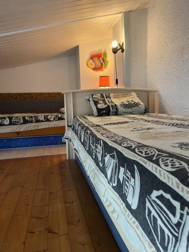 deux lits sont dans une pièce avec dans l'établissement Les Piimprenelles, à Saint-Jean-de-Monts