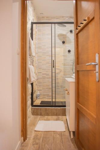 une salle de bain avec une douche avec une porte vitrée dans l'établissement La maison des artistes plein centre familiale, à Boulogne-sur-Mer