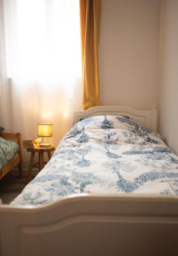 une chambre avec un lit avec une couette bleue et blanche dans l'établissement La maison des artistes plein centre familiale, à Boulogne-sur-Mer