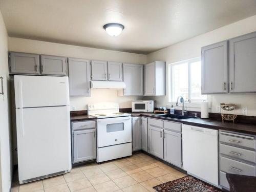 a kitchen with white cabinets and a white refrigerator at The Bike Barn in Vernal