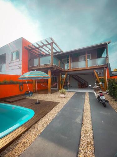 a house with a swimming pool next to a house at casa de praia em Navegantes SC in Navegantes