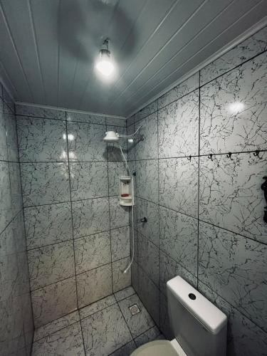 a bathroom with a toilet and a shower at Chalés Recanto da Aldeia in Itanhaém