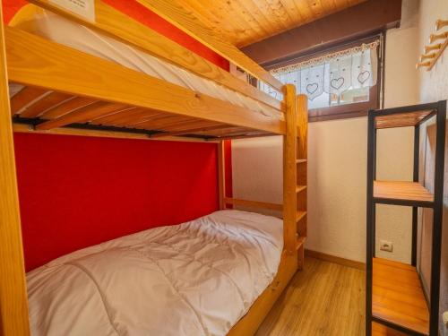 - une chambre avec 2 lits superposés et un mur rouge dans l'établissement Studio cabine avec terrasse, parking, 4 pers, centre village, proche pistes et commerces - FR-1-437-92, à La Clusaz