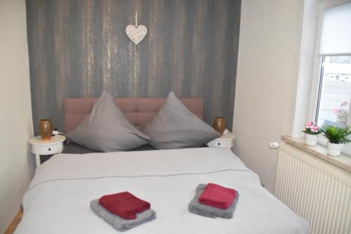 a bedroom with a bed with two red towels on it at Zur-kleinen-Auszeit in Benneckenstein