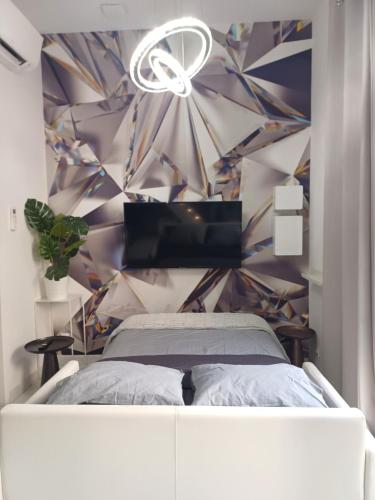 a bedroom with a bed and a colorful wall at Studio le diamant, 3pers, 2 lits, wifi in Agen