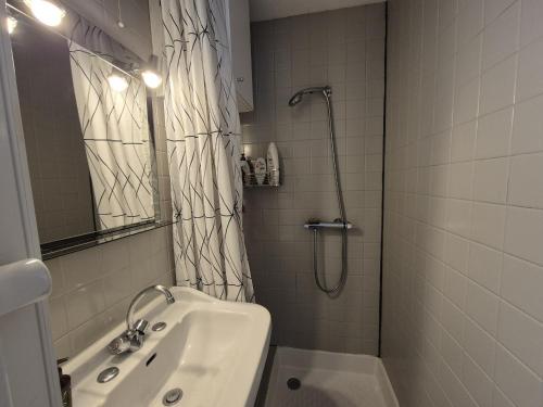 a bathroom with a shower and a sink and a shower curtain at Le Devallon in Saint-Jean-de-Monts