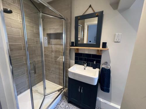 a bathroom with a shower and a sink and a mirror at St Helens House in Portsmouth