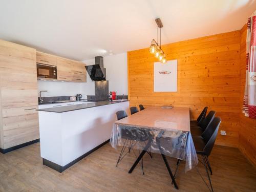 une cuisine avec une table, des chaises et un comptoir dans l'établissement Bel Appart 6 Pers - 2 Ch - Terrasse Sud - Garage - WIFI - La Clusaz - FR-1-437-105, à La Clusaz