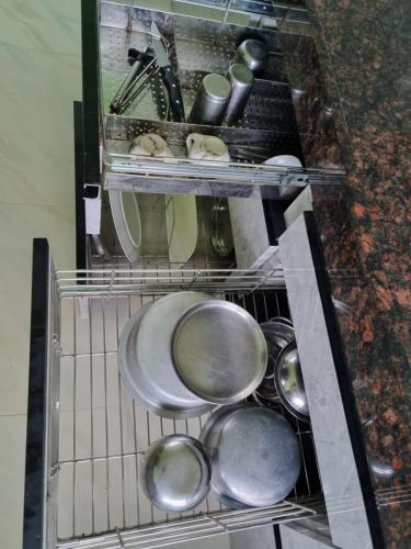 a bunch of pots and pans in a dishwasher at Relax stay in Belgaum