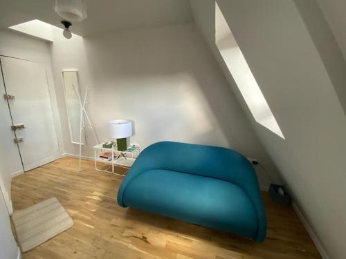 une chaise bleue dans une chambre avec escalier dans l'établissement Studio Victoria - Centre de Paris, à Paris