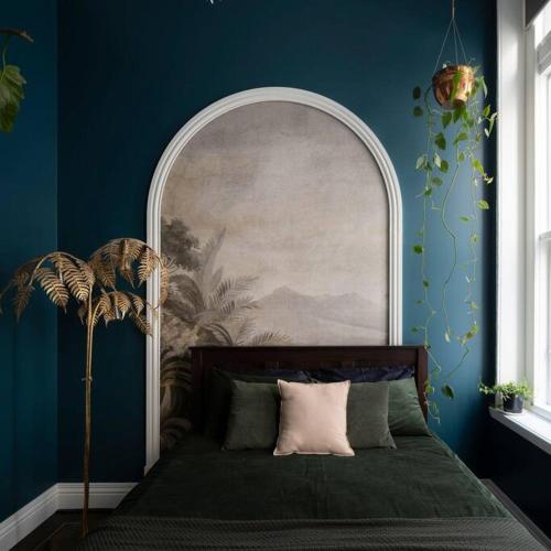 a bedroom with a bed with a blue wall at Degraves Della Casa- In the Heart of Melbourne CBD in Melbourne