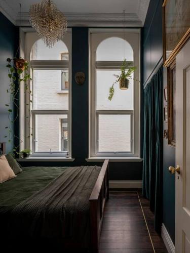 a bedroom with two windows and a bed with a bench at Degraves Della Casa- In the Heart of Melbourne CBD in Melbourne