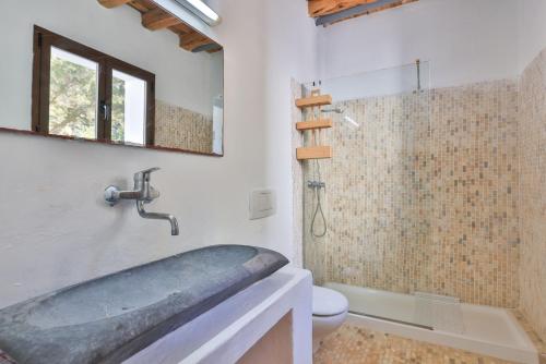 a bathroom with a tub and a toilet and a sink at Villa Kumharas in Santa Agnès de Corona