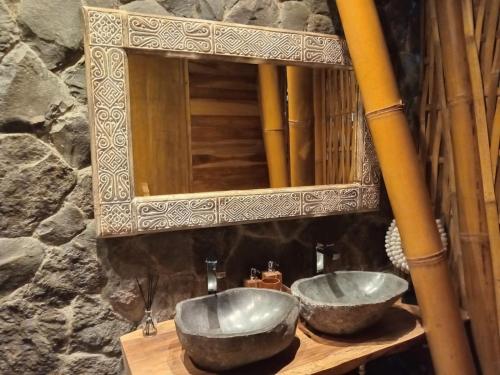 a bathroom with two sinks in front of a mirror at Villas Bukit Lipah in Amed