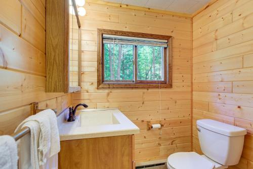 Un baño con lavabo, inodoro y ventana. en 2 Blocks to Boat Ramp Higgins Lake House with Grill, en Roscommon