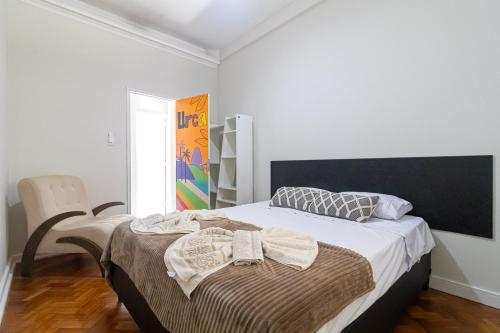 a bedroom with a bed and a chair at Maroca RIO in Rio de Janeiro