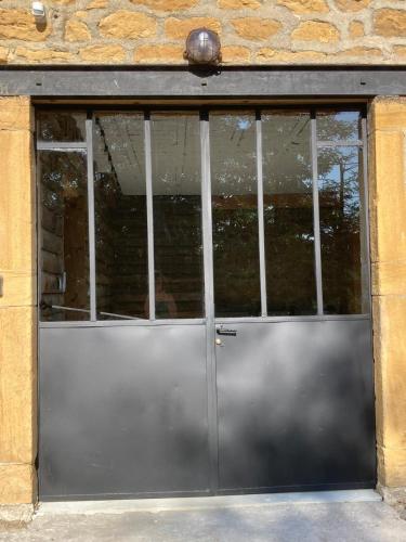 a large metal door in a stone building at Gîte Domaine du Berret 8 pers in Bully