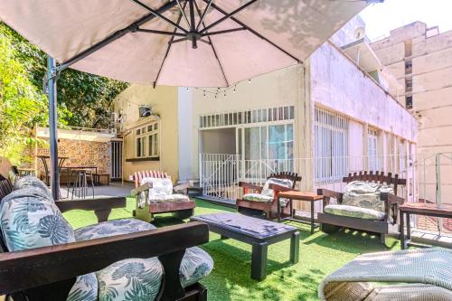 a patio with chairs and tables and an umbrella at Maroca RIO in Rio de Janeiro