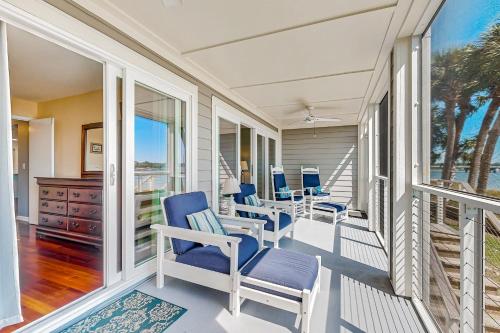 a porch with blue chairs and a dresser at Mariners Cay 40 in Folly Beach