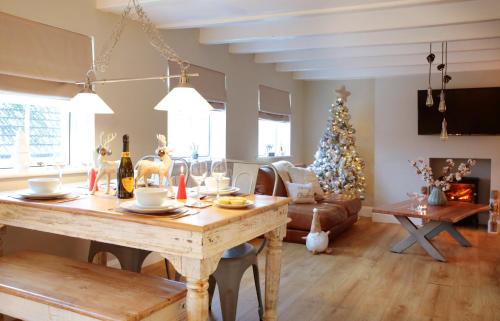 a living room with a table and a christmas tree at Glasswing Stays The Nest in Whitby