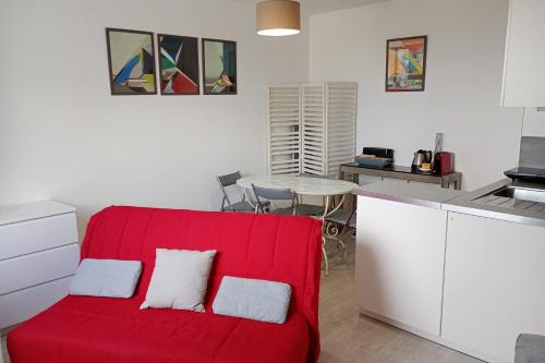 un salon avec un canapé rouge et une table dans l'établissement Charming 2 rooms in front of the Square Montholon, à Paris