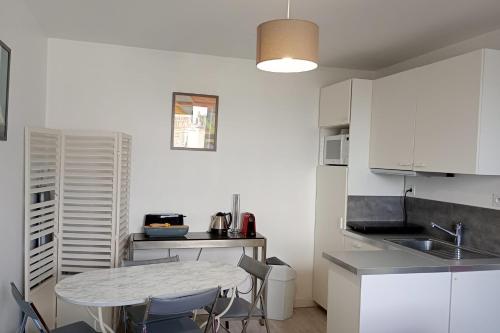 une cuisine avec une table et des chaises dans une pièce dans l'établissement Charming 2 rooms in front of the Square Montholon, à Paris