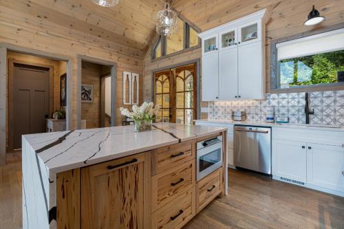 eine Küche mit weißen Schränken und einer Holzdecke in der Unterkunft Elevated Escape - Luxurious Mountain Views - Hot Tub, Game Room, Fire Pit, Full Mountain Views - Escape to Luxury North Georgia in Cherry Log