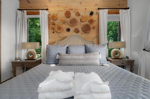 ein Schlafzimmer mit einem blauen Bett mit zwei Fenstern in der Unterkunft Elevated Escape - Luxurious Mountain Views - Hot Tub, Game Room, Fire Pit, Full Mountain Views - Escape to Luxury North Georgia in Cherry Log