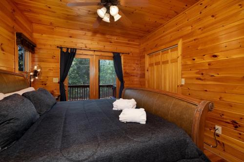 a bedroom with a bed in a wooden cabin at Escape to Dream Catcher - Enjoy cozy accommodations, and a variety of entertainment options including a hot tub, game room, and in Blue Ridge