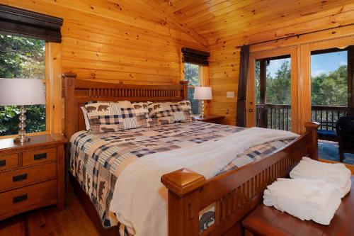 a bedroom with a bed in a log cabin at Escape to Dream Catcher - Enjoy cozy accommodations, and a variety of entertainment options including a hot tub, game room, and in Blue Ridge