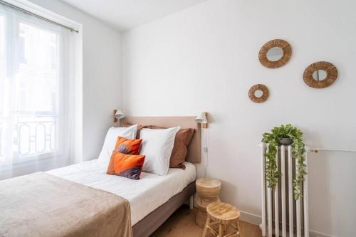 une chambre avec un lit avec des oreillers et une fenêtre dans l'établissement Studio au centre de Paris - Musée Grévin - II, à Paris