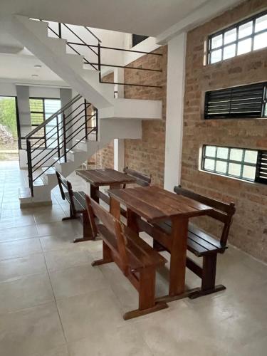 een eetkamer met 2 tafels en een trap bij Hospedaje El Caminante CAPI in Capitanejo