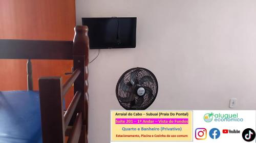 a fan on a wall with a tv on a wall at Arraial do Cabo – Subuai Village - Aluguel Econômico in Arraial do Cabo