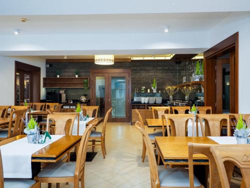a restaurant with wooden tables and wooden chairs at Giewont in Murzasichle