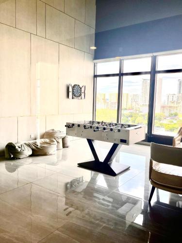 a room with a ping pong table in the middle at Georgetown Seaview & Cityview Childroom Infinity pool with Carpark in Jelutong