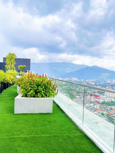 a balcony with green grass and flowers on a building at Georgetown Seaview & Cityview Childroom Infinity pool with Carpark in Jelutong