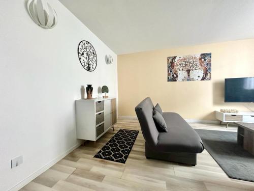 un salon avec une chaise et une télévision dans l'établissement L'Évêché lumineux et zen, à Limoges