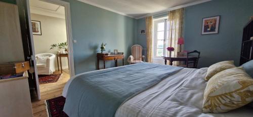une chambre avec un grand lit aux murs bleus dans l'établissement Chambres d'Hôtes Les Jardins de la Cathédrale, à Angoulême