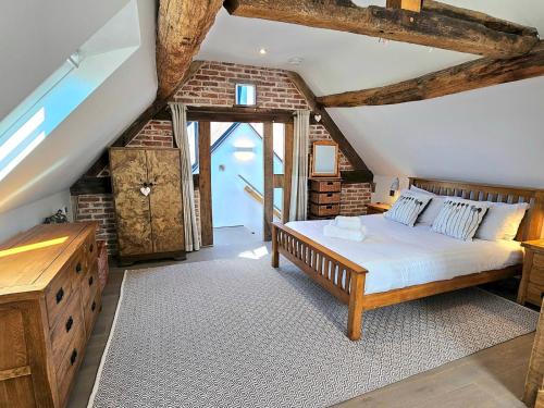 a bedroom with a large bed in a attic at Beautiful Views Historic 16th Cent Barn Conversion Pass the Keys in Bridgnorth
