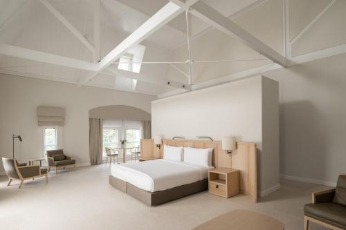 a bedroom with a white bed and a desk at COMO The Treasury in Perth