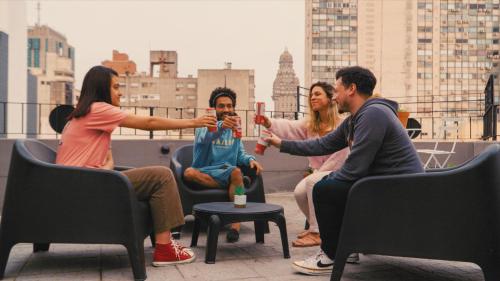 a group of people sitting on a rooftop drinking at Viajero Montevideo Hostel in Montevideo