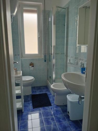 a bathroom with two toilets and a sink and a shower at Luli Holidays Paestum in Paestum