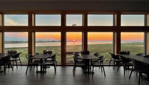 a restaurant with tables and chairs in front of a large window at Blackbush Beach Resort in Covehead