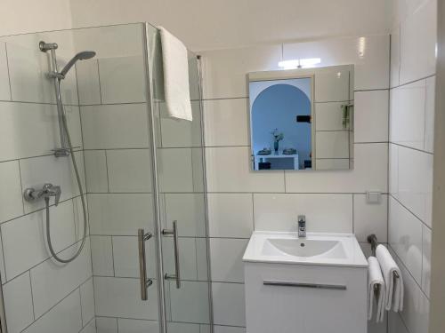 a bathroom with a shower and a sink and a mirror at Ferienwohnung Sieben, Zentral gelegene mit Tiefgaragenstellplatz in Bad Oeynhausen