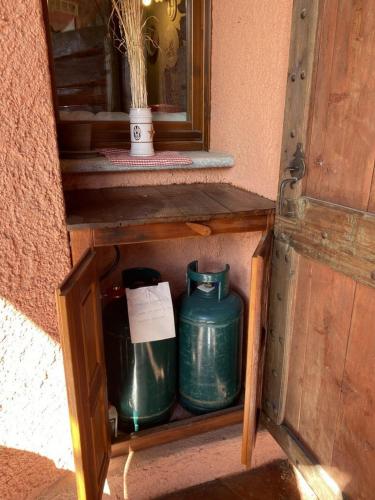 a wooden cabinet with two green pots in it at Baita Rousinette in Joussaud