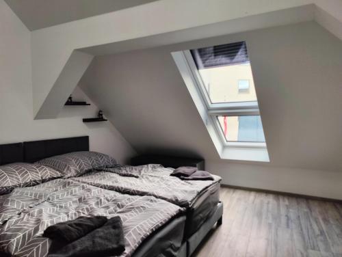 a bedroom with a bed and two windows at Villa Krems Wachau Apartments an der historischen Stadtmauer in Krems an der Donau