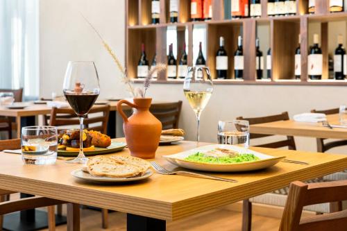 a table with a plate of food and wine glasses at Holiday Inn Beja by IHG in Beja
