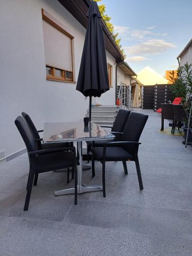 a table with chairs and an umbrella on a patio at Nationalpark Apartments in Apetlon